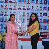 A faculty member presenting an award to a student during the testimonials event at Everest Coaching Point Faculty giving award to student during testimonials event at Everest Coaching Point