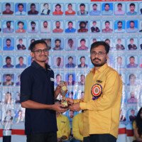 Maths faculty member presenting an award to a student during the testimonials event. Maths Sir giving award to student during testimonials event at Everest Coaching Point