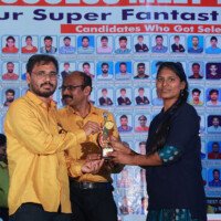 Maths faculty member honours a girl student during the testimonials program. Maths sir giving award to girl student during testimonials event at Everest Coaching Point