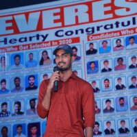 A motivated student sharing his success story on stage – photo gallery feature. Another boy delivering a speech on stage, shown in the photo gallery.