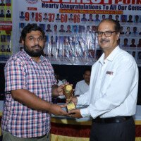 Jains Sir poses while awarding a successful student Jains Sir presenting award to student – testimonials of achievement and recognition
